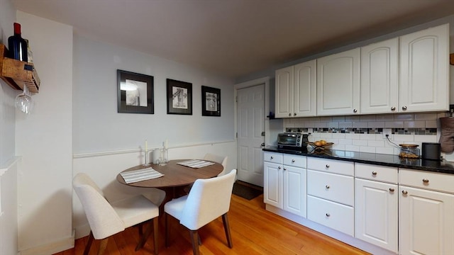 kitchen with backsplash, white cabinetry, and light wood-style floors