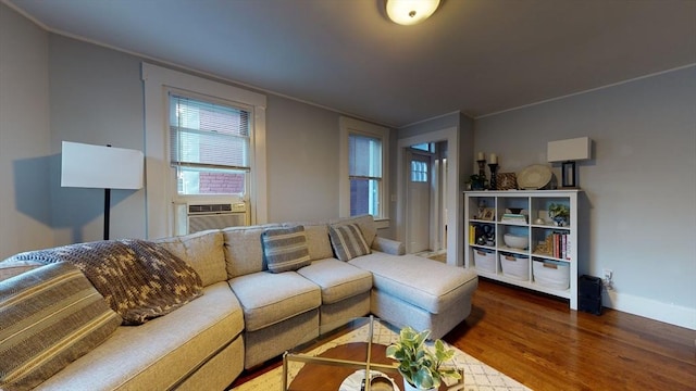 living room featuring cooling unit, baseboards, and wood finished floors