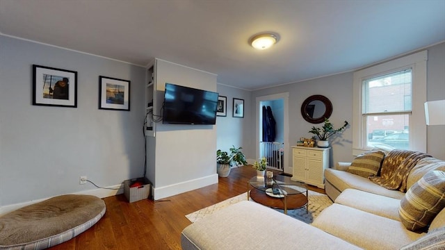 living area featuring ornamental molding, radiator, baseboards, and wood finished floors