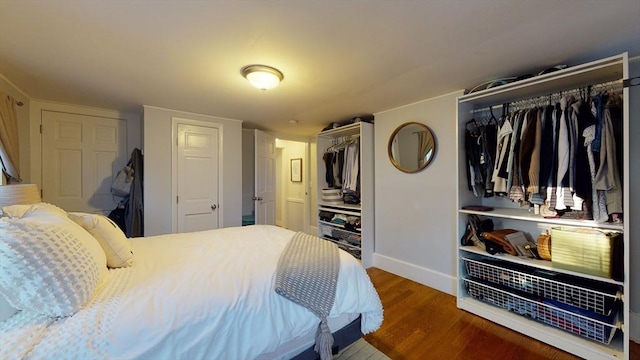 bedroom with baseboards and wood finished floors