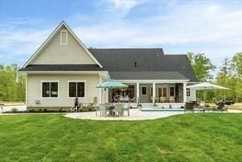 rear view of house featuring a lawn and a patio area