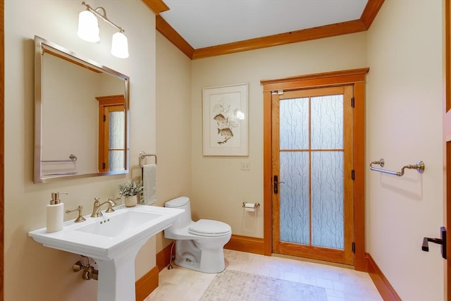 bathroom featuring sink, ornamental molding, and toilet