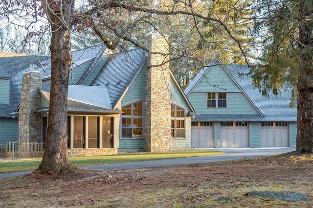 back of house featuring a garage and a sunroom