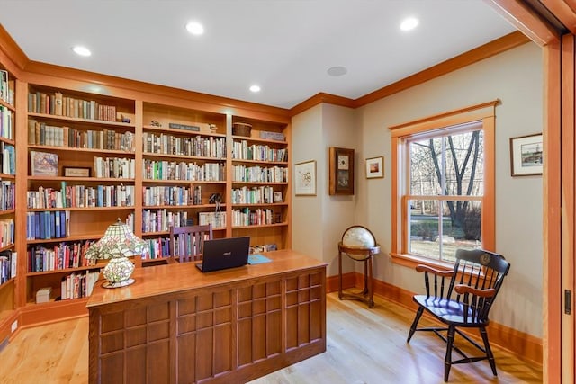 home office with crown molding, light hardwood / wood-style floors, and built in shelves