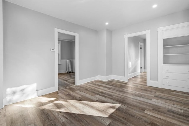 unfurnished room featuring radiator and wood-type flooring