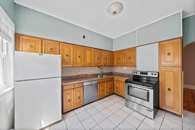 633 E Sixth St, Boston, MA 02127 - kitchen featuring stainless steel appliances, a sink, light tile patterned floors, brown cabinetry, and decorative backsplash