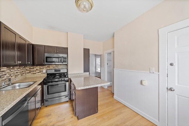 633 E Sixth St, Boston, MA 02127 - kitchen featuring appliances with stainless steel finishes, a sink, dark brown cabinets, light countertops, and a peninsula