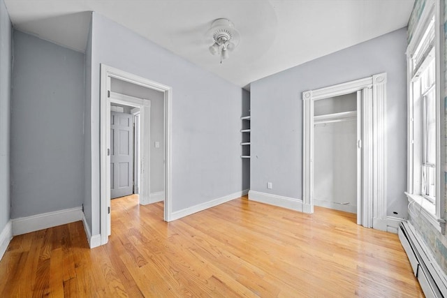 633 E Sixth St, Boston, MA 02127 - unfurnished bedroom featuring a baseboard radiator, multiple windows, light wood-type flooring, and baseboards