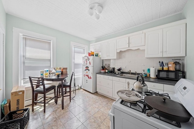 633 E Sixth St, Boston, MA 02127 - kitchen featuring white appliances, dark countertops, white cabinets, and a sink