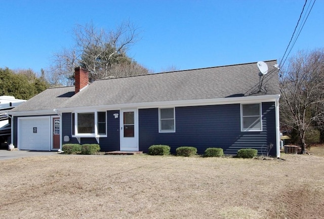 single story home with roof with shingles, a chimney, and an attached garage