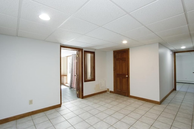 empty room featuring light tile patterned floors, recessed lighting, a paneled ceiling, and baseboards