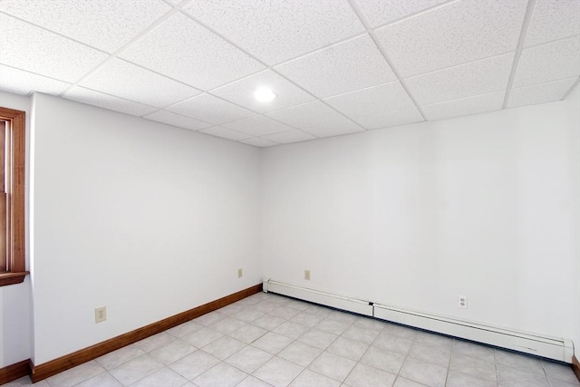 spare room with a drop ceiling, baseboards, and baseboard heating