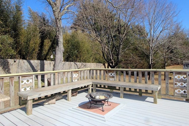 wooden deck featuring a fire pit and fence