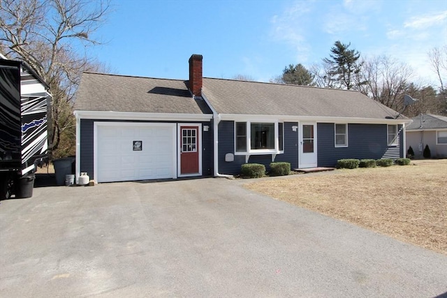 ranch-style home featuring a garage, roof with shingles, a chimney, and driveway