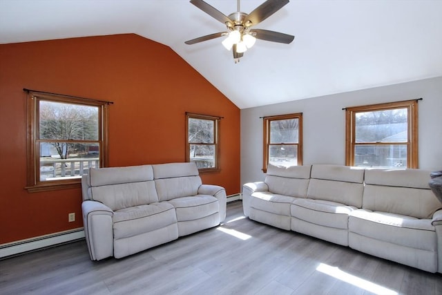 living room featuring plenty of natural light, wood finished floors, and vaulted ceiling