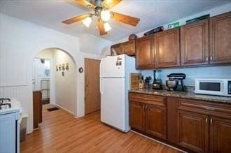 16-18 Orchard St, Grafton, MA 01560 - kitchen with white appliances, a ceiling fan, light wood finished floors, and arched walkways