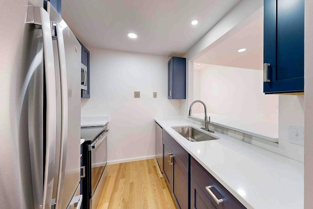 kitchen with sink, light hardwood / wood-style flooring, and appliances with stainless steel finishes