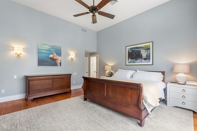 bedroom featuring hardwood / wood-style flooring, high vaulted ceiling, and ceiling fan