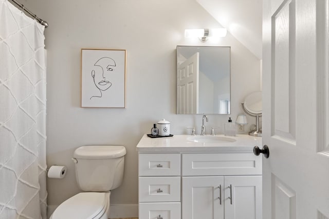 bathroom featuring toilet, lofted ceiling, and vanity