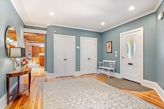 entrance foyer featuring ornamental molding and light hardwood / wood-style floors