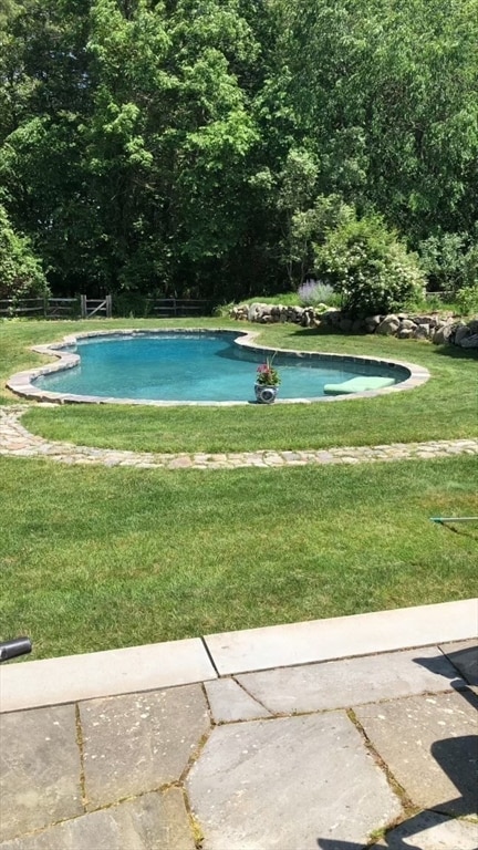 view of pool with a lawn