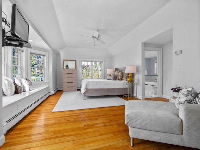 bedroom featuring light wood-style flooring, a baseboard heating unit, lofted ceiling, and multiple windows