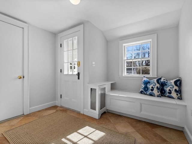 mudroom with light tile patterned floors, baseboards, and lofted ceiling