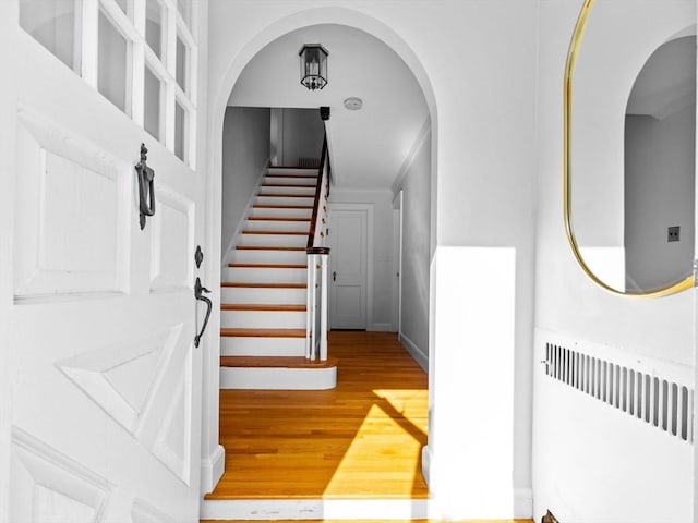 entrance foyer featuring stairs, wood finished floors, and radiator heating unit