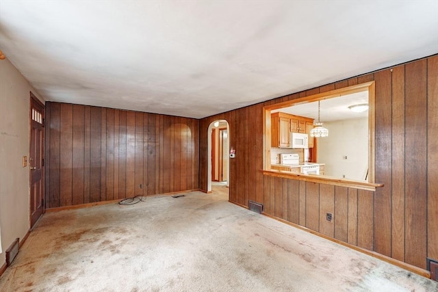 interior space with light carpet and wooden walls