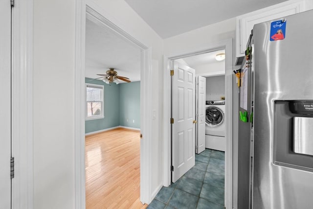 corridor featuring dark wood finished floors, washer / dryer, and baseboards