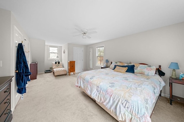 bedroom featuring a ceiling fan, light colored carpet, and baseboards