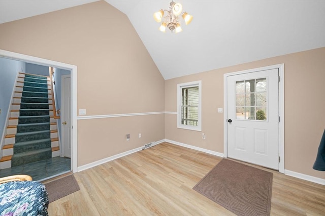 entryway with a notable chandelier, visible vents, baseboards, stairway, and light wood finished floors