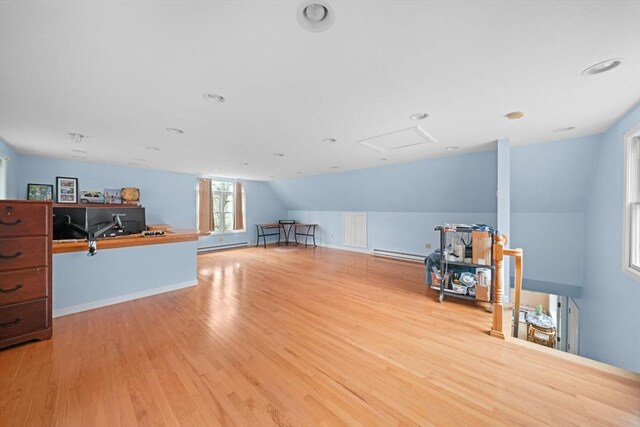 interior space featuring a baseboard radiator, lofted ceiling, recessed lighting, attic access, and wood finished floors