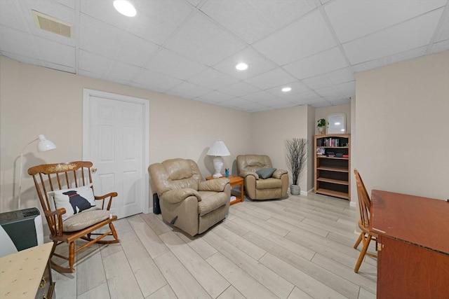 sitting room featuring light wood-style floors, visible vents, a drop ceiling, and recessed lighting