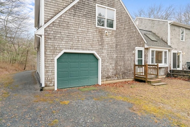 view of property exterior with driveway and roof with shingles