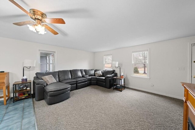 living area featuring ceiling fan, carpet, and baseboards