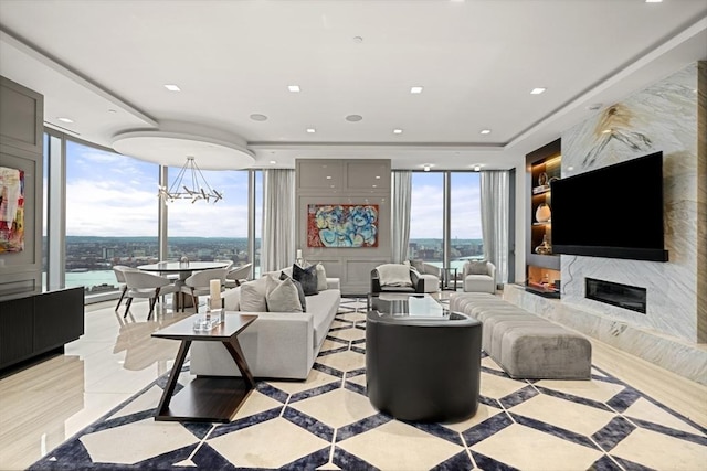 living room featuring a water view, an inviting chandelier, and a fireplace