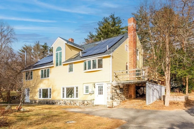 view of property exterior with a deck and solar panels