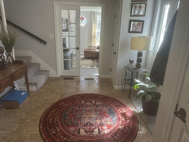foyer featuring stairway and baseboards