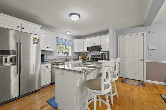 3 Spindletop Dr, Leominster, MA 01453 - kitchen with stainless steel appliances, white cabinets, a kitchen bar, light wood-style flooring, and light stone counters