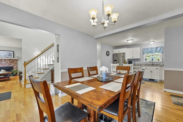 3 Spindletop Dr, Leominster, MA 01453 - dining area with stairs, a fireplace, a chandelier, and light wood-style flooring