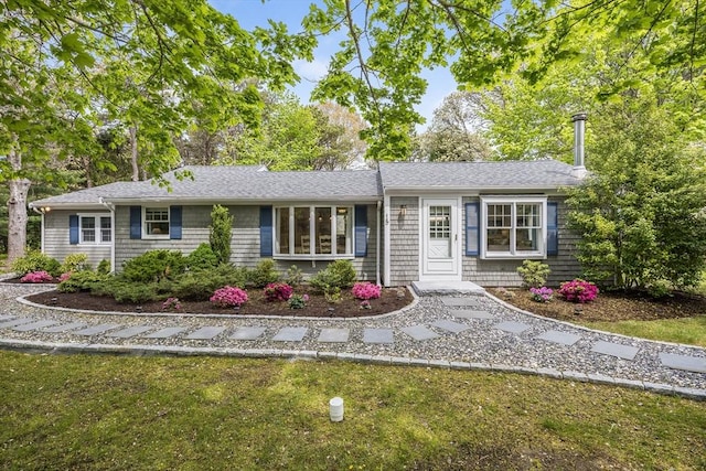 single story home with a front yard and roof with shingles