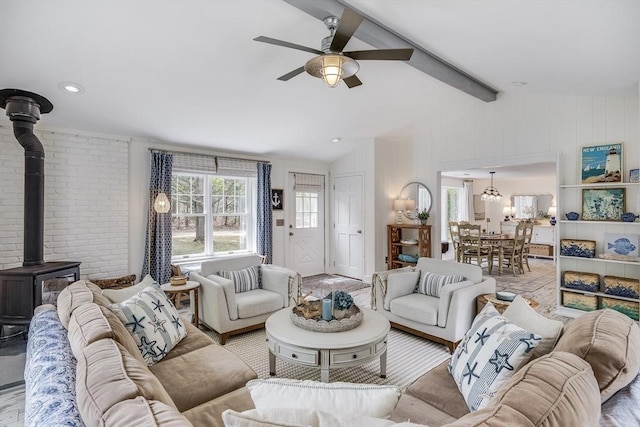 living room featuring a wood stove and a ceiling fan