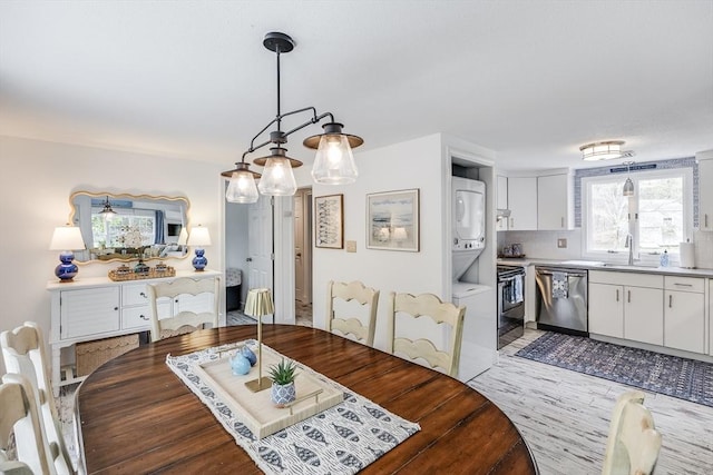 dining room with stacked washer and clothes dryer and light wood finished floors