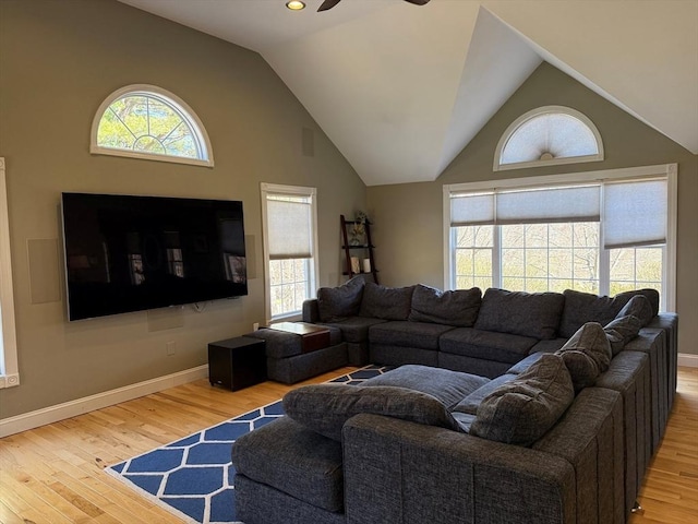 living area featuring wood finished floors, baseboards, a ceiling fan, and vaulted ceiling