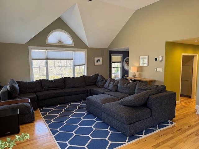 living room with high vaulted ceiling and light wood finished floors