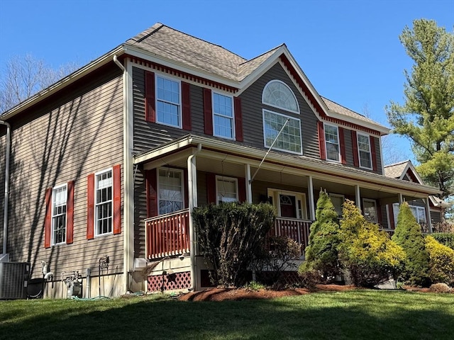 colonial inspired home with central AC, a porch, and a front lawn