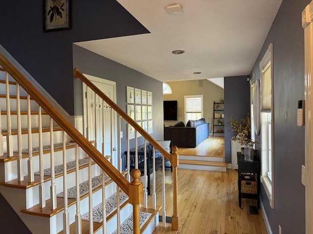 staircase featuring hardwood / wood-style floors and baseboards