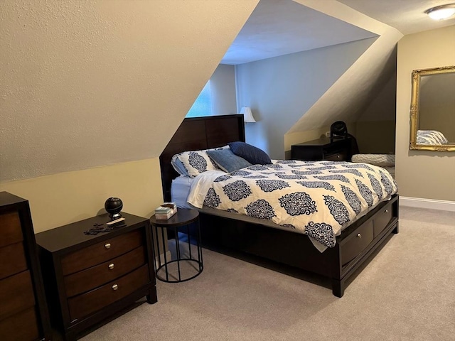 bedroom featuring light carpet, baseboards, and lofted ceiling