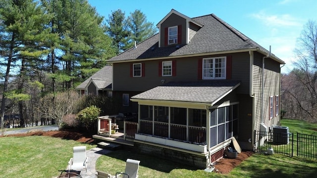 rear view of property featuring a shingled roof, a sunroom, a yard, fence, and central air condition unit